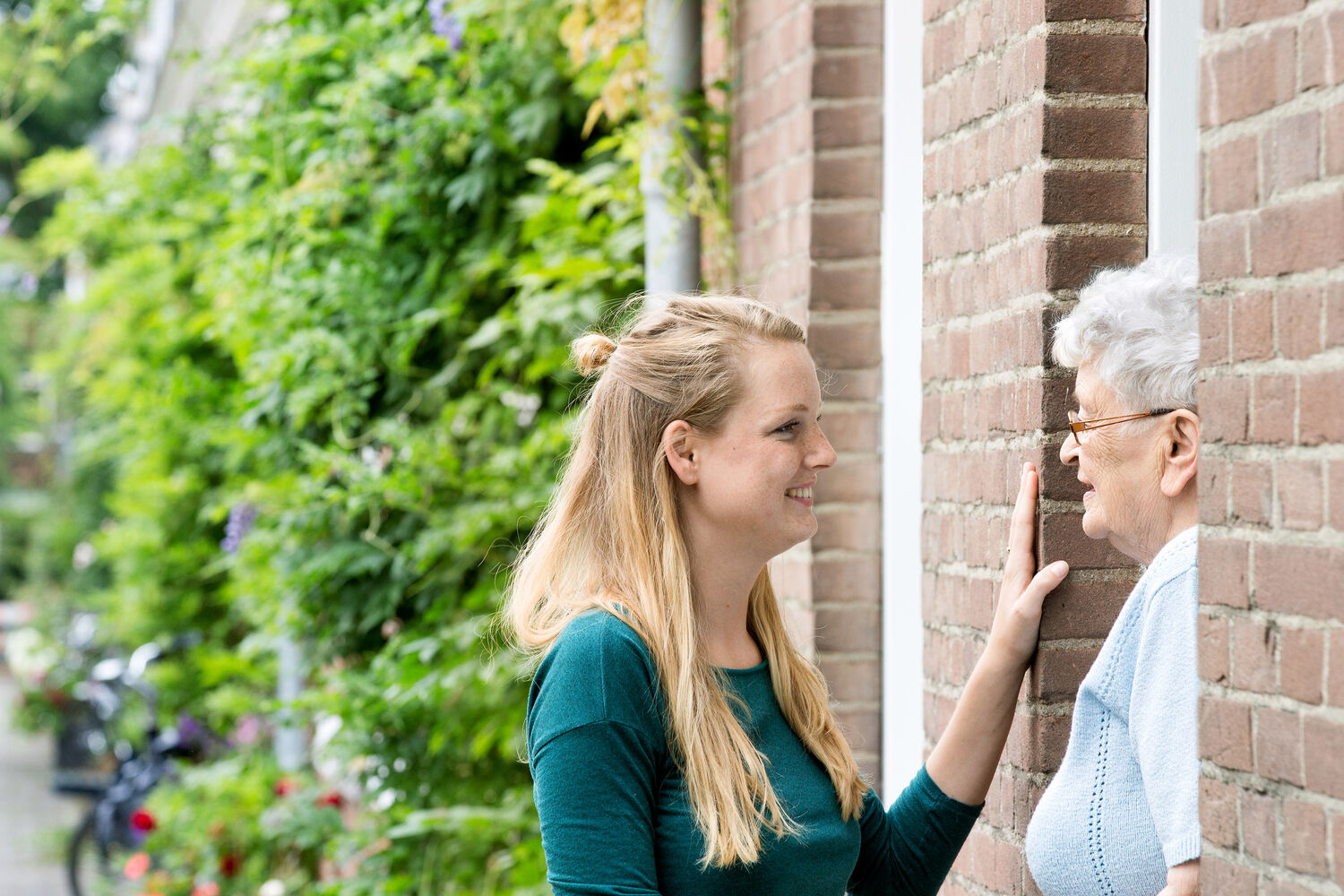 Kleindochter en oma staan in deuropening