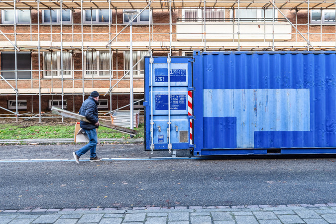renovatie Aarveld Heerlen- man brengt spullen naar container