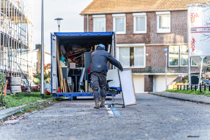 Renovatie Aarveld Heerlen - man brengt oude spullen naar container
